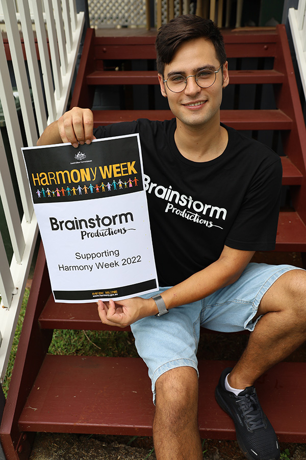 James holding a Harmony Week 2022 poster