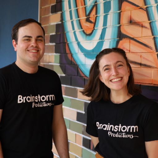 Actors Miriam and Clayton smiling for the camera in their Brainstorm t-shirts