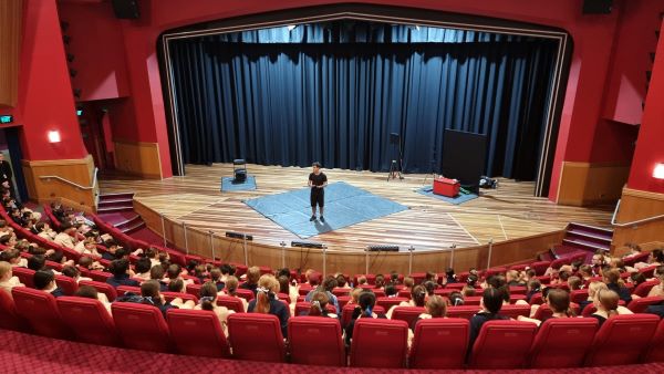 A Brainstorm Productions actor is facilitating a discussion with QLD high school students on the National Day of Action 2023