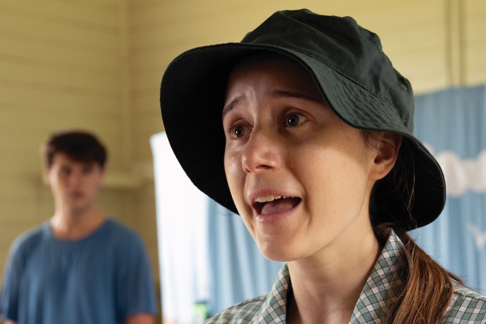 A still from the primary school performance Being Brave. An actor is dressed in a school uniform and singing with emotion.