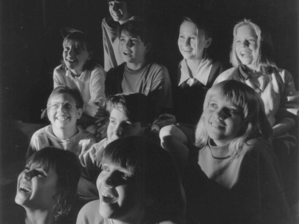 A photo from the 1980s of a group of high school students watching a Brainstorm Productions performance.