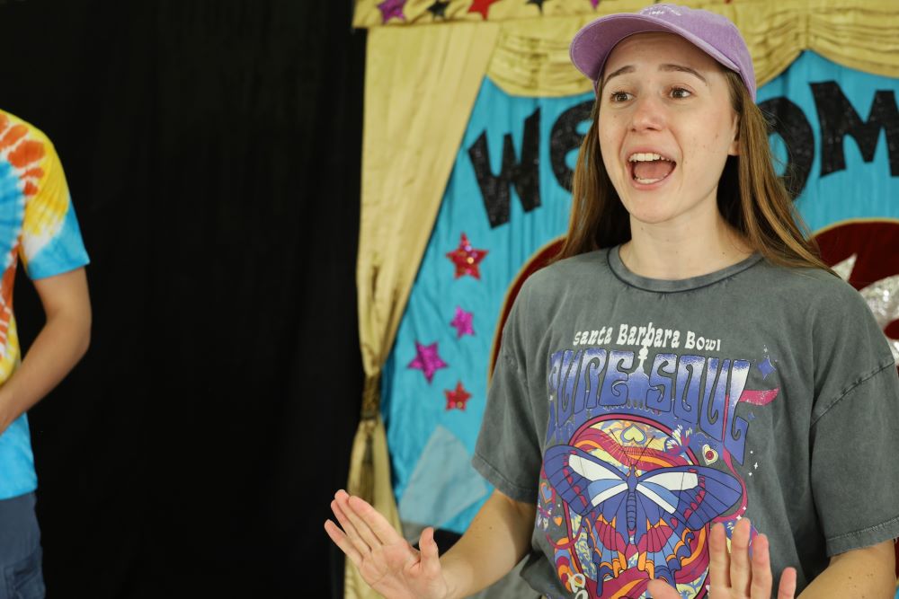 An actor is singing happily during a Brainstorm Productions show for primary schools