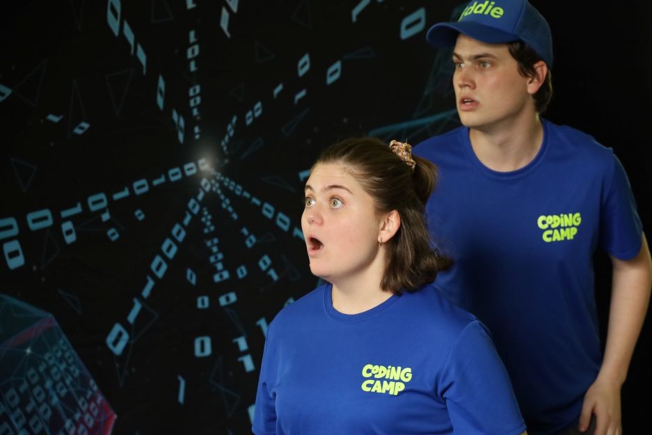 Two Brainstorm actors during a performance of the primary school performance Zanna and the Lost Code - both are looking outside the frame with a shocked expression.
