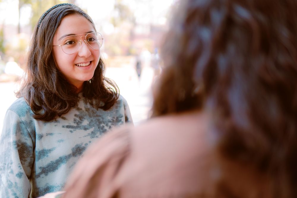 A teenage girl is talking to a trusted adult