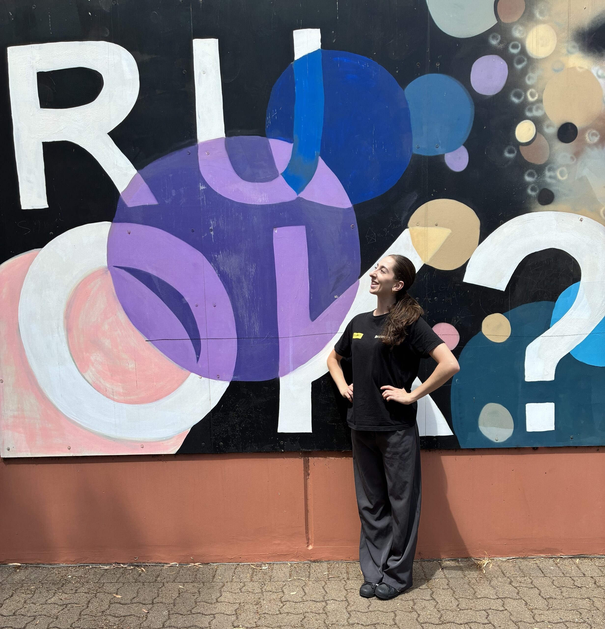 A Brainstorm Productions actor in front of an R U OK mural at Blackwood High School in Adelaide SA