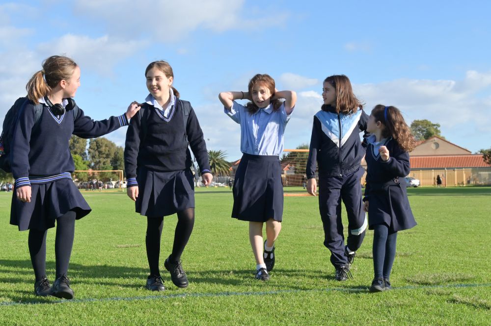A group of Australian high school students walking together and smiling and laughing